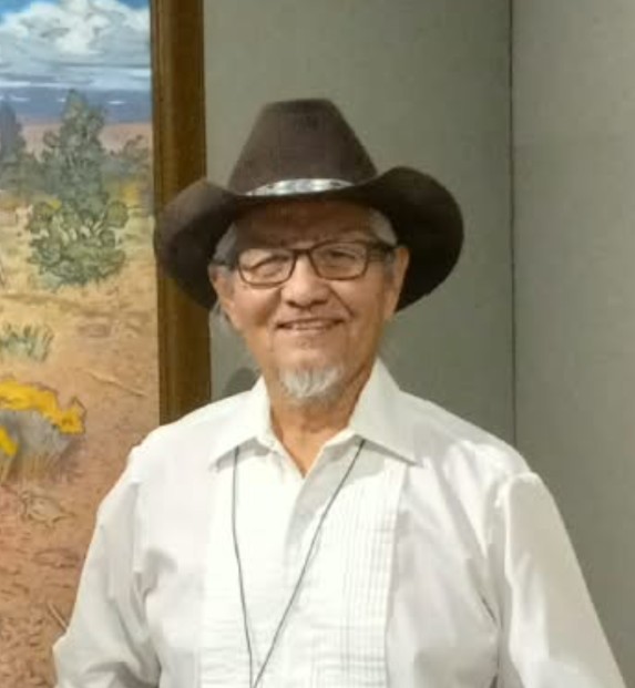 Portrait of Master Artist Johnson Yazzie wearing a cowboy hat and glasses.